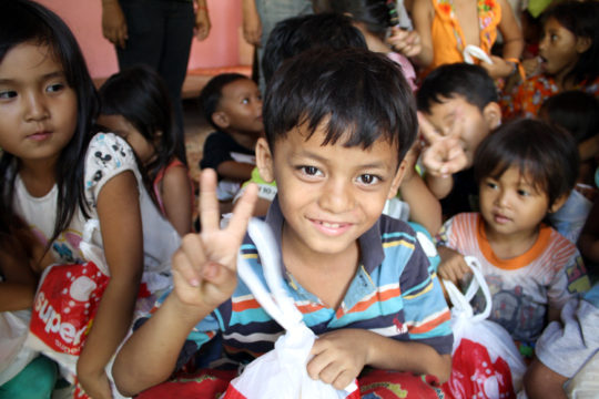 お菓子を持つカンボジアの子供の笑顔