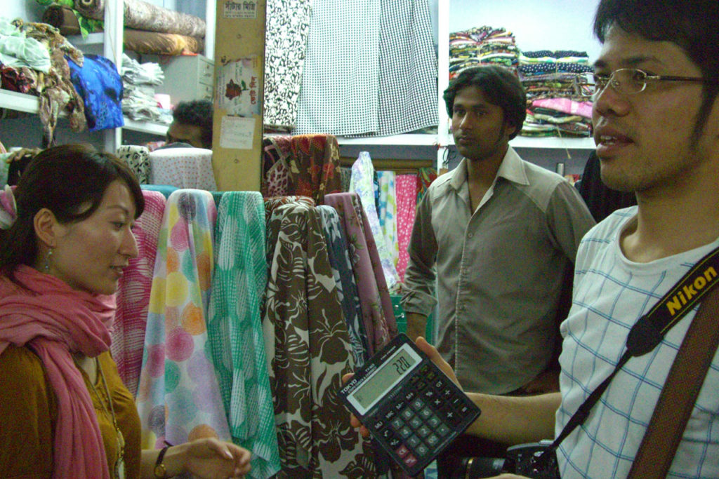 バングラデシュの市場で電卓で金額交渉