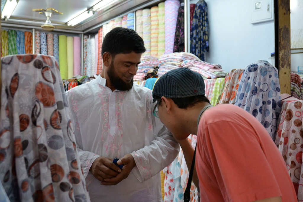 バングラデシュの市場で生地をを確認する