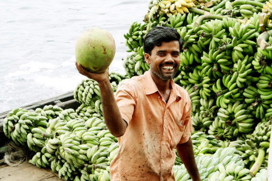 ショドルガット港でココナツを持つ笑顔のバングラデシュ人