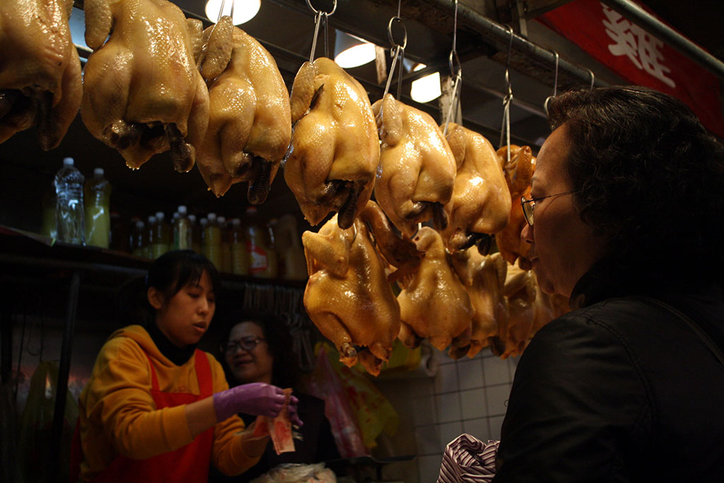 台北の商店街で肉を物色するおばさん