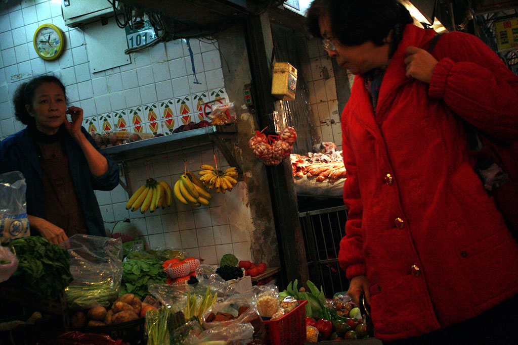 台北の商店街で野菜を見るおばさん